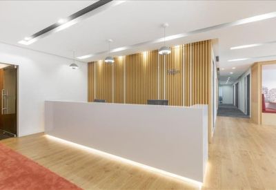 Bright reception desk with minimalist design, wood-paneled feature wall, and warm downlighting.