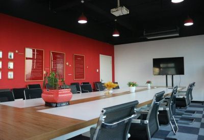 Spacious boardroom with a red feature wall and wood-trimmed conference table.