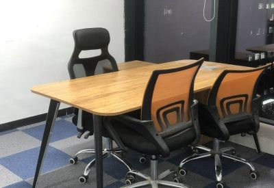 Collaborative workstation with orange desk dividers and ergonomic chairs.