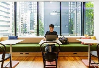 Individual workstation with a laptop overlooking a large window with city views.