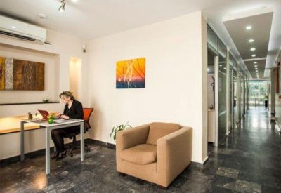 Modern reception area with a dedicated workspace and a long corridor.