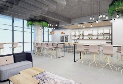 Reception area with a sleek white desk, high stools, and hanging bulb light fixtures.