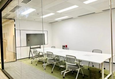 Minimalist conference room with a long white table and glass walls.