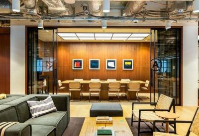 Modern meeting room with a long wooden table behind glass partitions.