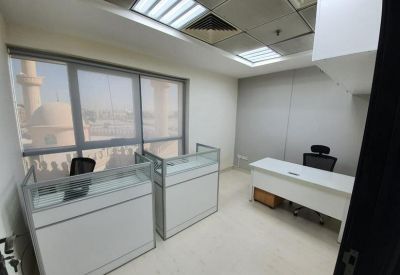 Private white office with large windows and two workstations.