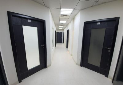 Clean white hallway with dark office doors.