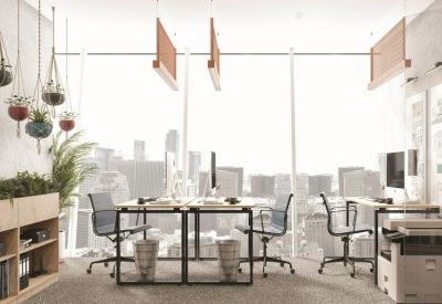 Bright open-plan workspace with multiple desks and floor-to-ceiling windows overlooking the city.