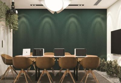 Professional meeting room featuring a green slatted wall and modern tan seating.