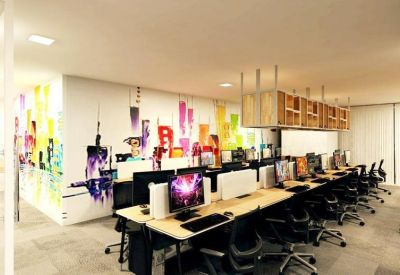 Creative workspace area featuring a colorful city skyline mural and long rows of computers.