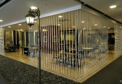 Breakout area featuring a rope-partitioned lounge space and dark pebble flooring.
