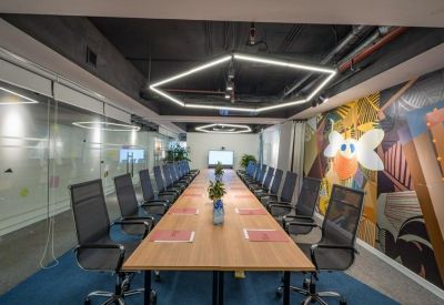 Large meeting room with a long wooden table, black mesh chairs, and vibrant wall graphics.