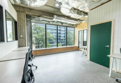 Light-filled workspace with floor-to-ceiling windows overlooking greenery.