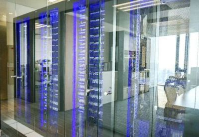 Office corridor featuring glass partitions with vertical blue light accents.