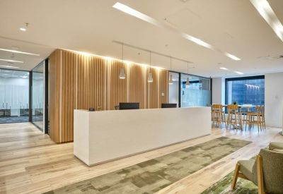 Bright reception area featuring a white stone desk and wood-panelled accent wall.