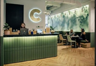 Modern reception desk with a large glowing C logo and lounge seating.