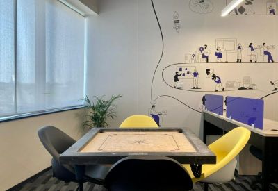 Breakout area with a carrom board table and playful wall illustrations.