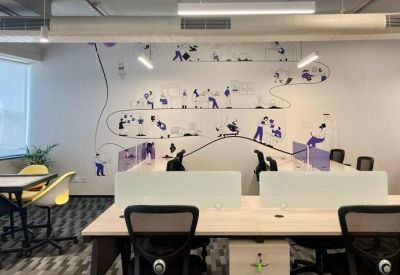 Coworking zone with a large illustrated mural and a mix of casual and formal seating.