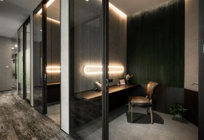 Private glass-walled workspace with a built-in desk and ergonomic chair.