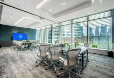 Bright conference room with a large screen and floor-to-ceiling windows.
