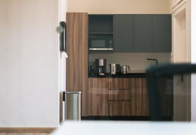 Compact kitchenette with dark grey cabinetry and wood-finish lower cupboards.
