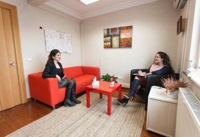 Consultation room featuring a bright red sofa and matching coffee table.