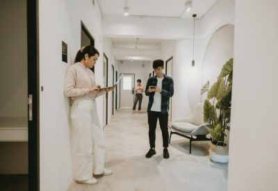 Bright white corridor featuring a minimalist seating bench and indoor greenery.