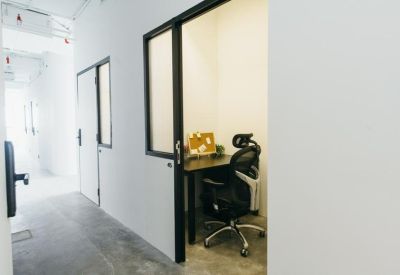 Bright private office pod with a desk and ergonomic chair.