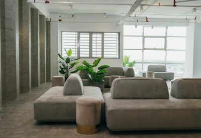Spacious lounge area with modern grey modular seating and indoor plants.