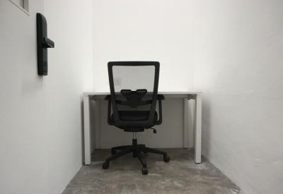 Private office suite with a white desk and a black mesh ergonomic chair.