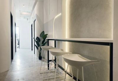 Communal breakout area with a high bar counter, white stools, and warm accent lighting.
