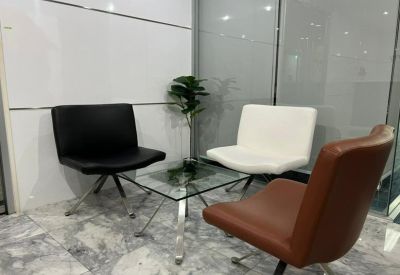 Reception seating area with black, white, and brown chairs around a glass coffee table.