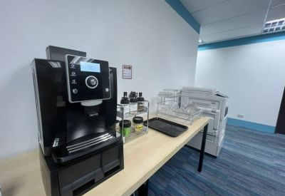 Close-up of a professional espresso machine on a communal kitchen counter.