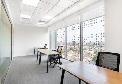 Bright coworking area with colorful teal chairs, wood tables, and integrated booth seating.