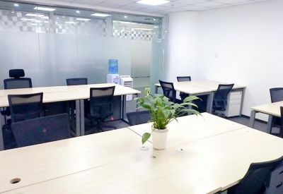Workspaces with light wood desks, individual pedestals, and a frosted glass partition.