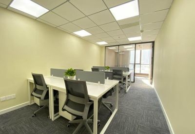 Bright office workspace with white desks and black ergonomic chairs.
