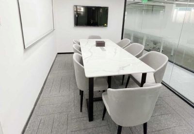 Professional meeting room featuring a white marble table and grey seating.