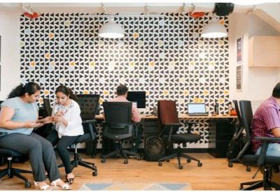 Open plan office area with workstations against a geometric patterned feature wall.