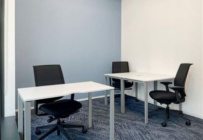 Private office suite with two white desks and black ergonomic chairs.