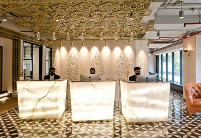 Grand reception lobby with glowing onyx desks and ornate patterned ceiling.