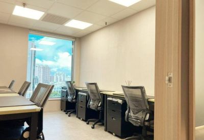 Bright office space with multiple workstations and large windows.