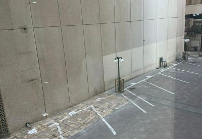 View from an upper floor looking down at a paved parking area and building exterior.