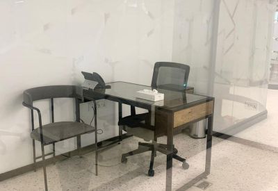 Minimalist single-person desk with a wooden drawer and black mesh chair.