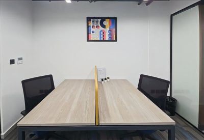 Symmetrical two-person workstation featuring a central divider and colorful abstract wall art.
