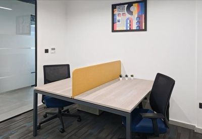 Two-person desk configuration with a yellow privacy screen and ergonomic mesh chairs.