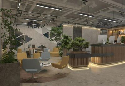Reception lobby with a wooden front desk, warm lighting, and indoor greenery.