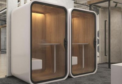 Pair of private soundproof phone booths with glass doors and wooden interiors.