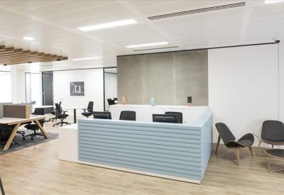 Modern reception area featuring a light blue slatted desk and wooden flooring.
