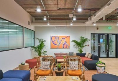Spacious lounge area with orange armchairs, navy sofas, and vibrant wall art.