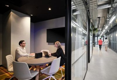 Private small-group meeting room with a round table and views into the hallway.