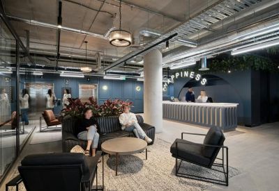 Reception area with a textured desk, lounge seating, and a large Happiness sign on the wall.